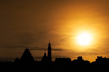 Panoramic view for the Warsaw Old town under the setting sun.. Contours of buildings against the sky with turned up colors