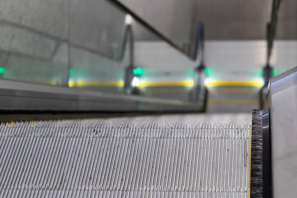 Escalators in an underground pedestrian passage. Close-up of steps detail - shallow depth of field. Underground urban infrastructure