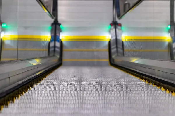 Escalators in an underground pedestrian passage. Close-up of steps detail - shallow depth of field. Underground urban infrastructure