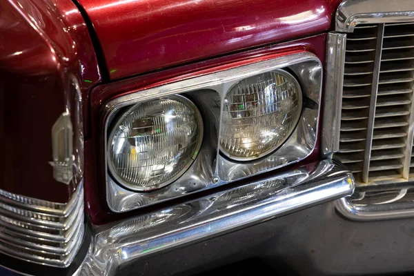 赤いアメリカのクラシックカーのラウンドヘッドライトのクローズアップ 歴史的な車両のクロムの詳細上の天然のパティーン — ストック写真