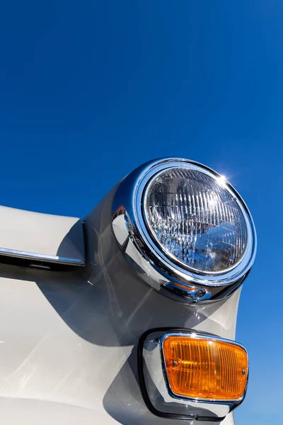 白いクラシックカーのラウンドヘッドライトとオレンジのターン信号のクローズアップ 歴史的な車両の美しく復元されたクロムの詳細 — ストック写真