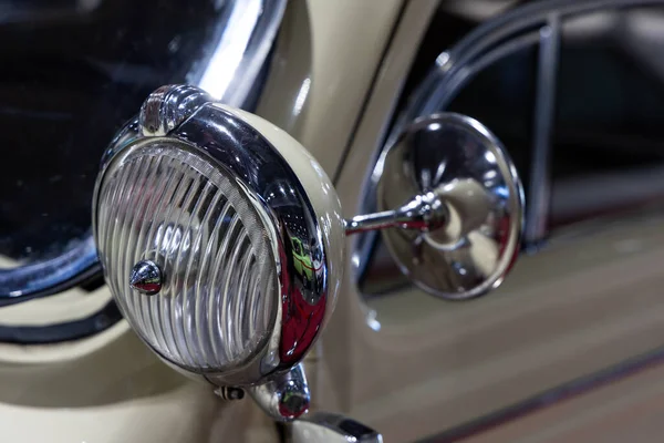 ベージュのクラシックカーのラウンドヘッドライトのクローズアップ 歴史的な車両の美しく復元されたクロムの詳細 — ストック写真