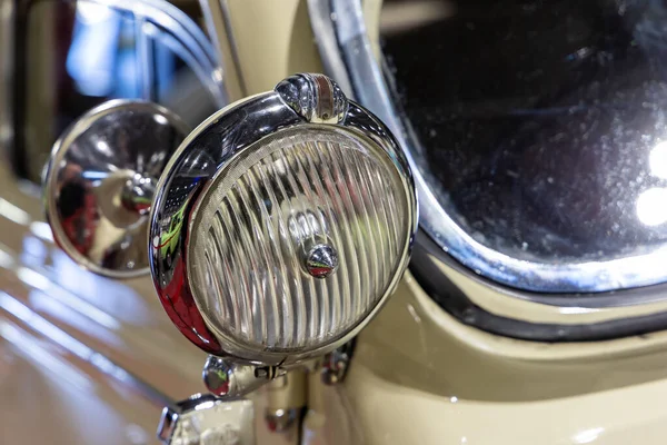 ベージュのクラシックカーのラウンドヘッドライトのクローズアップ 歴史的な車両の美しく復元されたクロムの詳細 — ストック写真