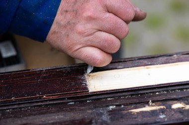 Ahşap elementleri keskiyle işleyen bir adamın elleri. Profesyonel el işi yap ve kendin yap.