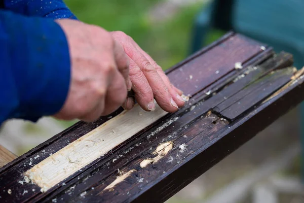 stock image Hands of a man processing wooden elements with a chisel. Professional hand craft work and do it yourself