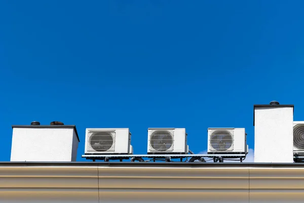 大楼屋顶上有许多空调机 在阳光灿烂的一天 在蓝天的映衬下拍摄 — 图库照片