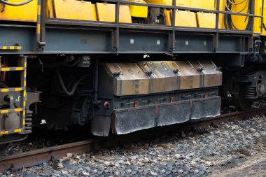 Demiryolu kenarında duran rayları öğütmek için sarı teknik tren. Öğütücüye yakın çekim. 