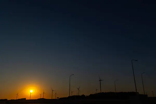 日落时 许多风力涡轮机在橙色的天空下缓慢旋转 傍晚时分发生的静态枪击事件 — 图库照片