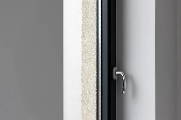 stock image Tilt and turn window handle in a large window in a public building. The window is made of plastic, visible silicone seals.