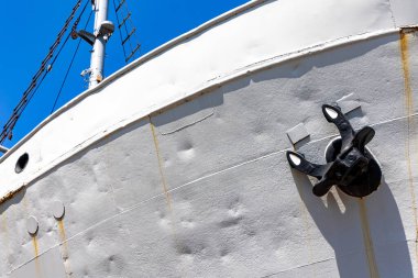 Tarihi bir balıkçı teknesi sudan çıkarıldı ve müzenin rıhtımında sergilendi. Güneşli bir günde, mavi gökyüzüne karşı çekilen bir gemi.