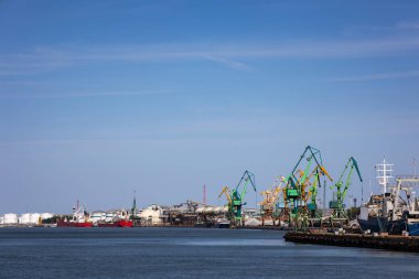 Rıhtımda birçok liman vinci var. Toptan malzeme kullanımı. Fotoğraf güneşli bir günde çekildi..