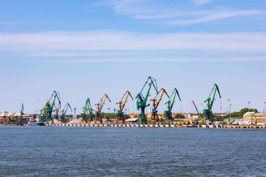 Rıhtımda birçok liman vinci var. Toptan malzeme kullanımı. Fotoğraf güneşli bir günde çekildi..