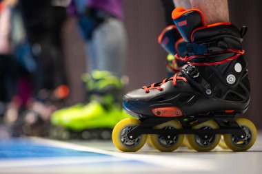 Spor salonunda artistik patinaj eğitimi alan insanların patenlerine yakın çekim. Fotoğraf spor salonunun yapay ışıklandırmasıyla çekildi..