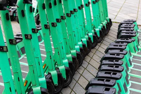 緑色の電動スクーターが市街地の歩道に駐車している 家賃のための都市の個人的な交通機関車 — ストック写真