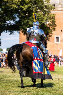 Golub Dobrzyn, Polonya, Masovia Voyvoda, 7 Temmuz 2023. Atın üstünde tarihi zırh giyen ağır silahlı bir şövalye. Fotoğraf, güneşli bir günde bir şövalye turnuvası sırasında çekildi..
