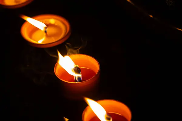 Night shot of the flames of glass cemetery candles standing on tombstones. The shot was taken during All Saints\' Day, November 1.