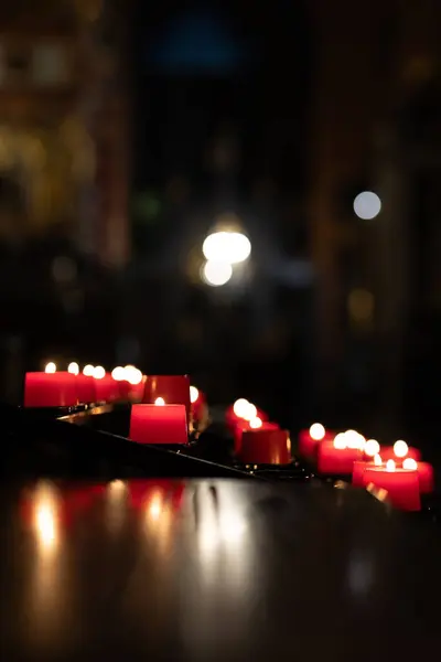 Votive candles burning peacefully in the church. Votive thanks in the Christian religion. Photo taken in a dark church