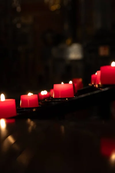 Votive candles burning peacefully in the church. Votive thanks in the Christian religion. Photo taken in a dark church