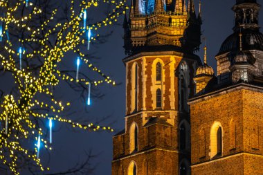 Krakow 'daki Aziz Mary Bazilikası' nın arka planındaki Noel süslenmiş ağaçlara karşı. Krakow 'un Eski Kasabasının Gece Manzarası.