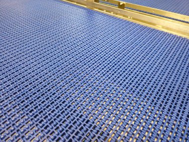 Modüler endüstriyel taşıyıcı sistemindeki mavi poliüretan bandın yakın çekimi. Endüstriyel fabrikalarda ulaşım sistemleri.