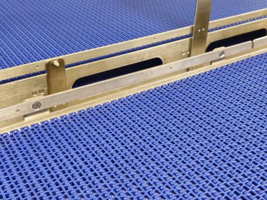 Modüler endüstriyel taşıyıcı sistemindeki mavi poliüretan bandın yakın çekimi. Endüstriyel fabrikalarda paslanmaz çelik taşıma sistemleri.