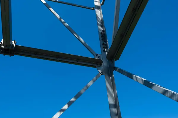 stock image Bolted connections of steel elements of the observation tower. Construction details of galvanized steel against a blue sky background.