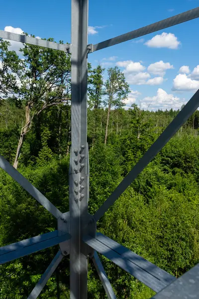 stock image Bolted connections of steel elements of the observation tower. Construction details of galvanized steel against a green trees background