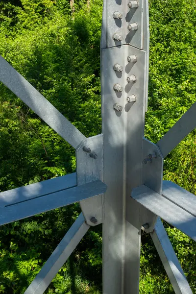 stock image Bolted connections of steel elements of the observation tower. Construction details of galvanized steel against a green trees background