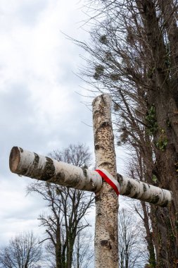 A birch cemetery cross with an emblem in Polish national colors. A cross commemorating soldiers who died during the Polish war clipart