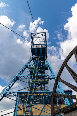 Mavi kömür madeni hassas bulutlu mavi gökyüzüne karşı. Fosil yakıt üretiminin yenilenebilir yakıtlar lehine azaltılması