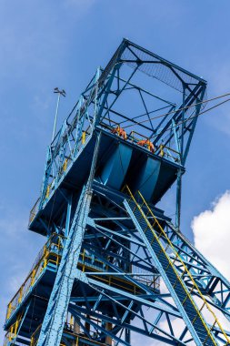 Mavi kömür madeni hassas bulutlu mavi gökyüzüne karşı. Fosil yakıt üretiminin yenilenebilir yakıtlar lehine azaltılması