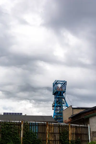 stock image Blue coal mine shaft against cloudy sky with dramatic clouds. Reduction of fossil fuel extraction in favor of renewable fuels