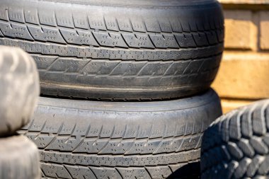 Çöpe atılmış eski lastiklerin aşınmış ve hasarlı izleri. Lastik atığı nedeniyle yol güvenliği ve çevre kirliliği azaldı
