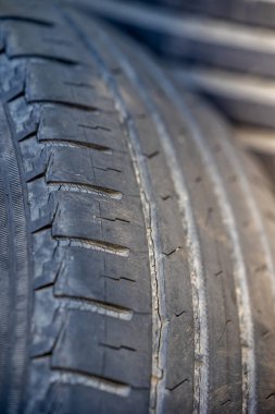 Worn and damaged tread of old tires lying in a landfill. Decreased road safety and environmental pollution from rubber waste clipart