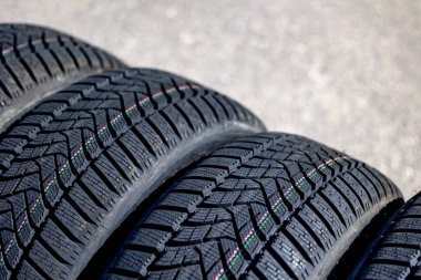 Sharp tread of new winter tires ready for the seasonal change. New tires are important for increasing road safety clipart