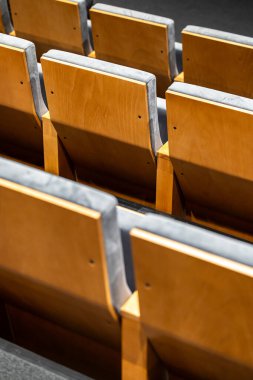 Sinema salonundaki boş koltuklar, sığ alan derinliği olan yakın çekim. Hafif kontrplaktan yapılmış arka kısmın görüntüsü.