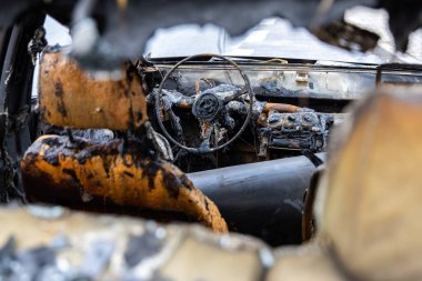 Yanmış bir yolcu vagonunun içi. Yangın nedeniyle araçta büyük hasar var. Fotoğraf bulutlu bir günde çekildi.