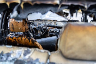 Yanmış bir yolcu vagonunun içi. Yangın nedeniyle araçta büyük hasar var. Fotoğraf bulutlu bir günde çekildi.