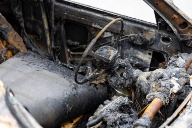 Yanmış bir yolcu vagonunun içi. Yangın nedeniyle araçta büyük hasar var. Fotoğraf bulutlu bir günde çekildi.