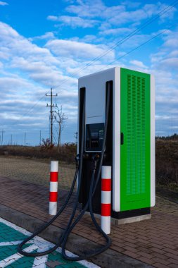 Otoyoldaki bir sürücünün dinlenme yerinde elektrikli araba şarjı. Fotoğraf güneşli bir günde çekildi..