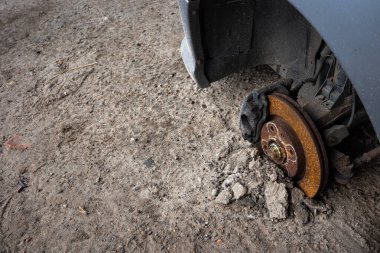 Terk edilmiş bir yolcu vagonunun paslı merkezi. Gri bir arabanın görünür tekerlek kemerleri. Fotoğraf doğal ışıklandırma koşullarında çekildi.