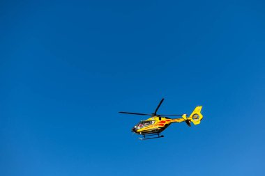 Grodzisk Mazowiecki, Masovia Voyvodalığı, Polonya. 3 Aralık 2024. Sarı LPR helikopteri kurtarma görevinde mavi gökyüzüne doğru uçuyor..