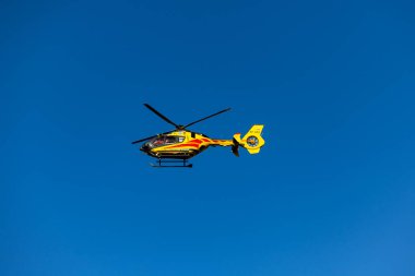 Grodzisk Mazowiecki, Masovia Voyvodalığı, Polonya. 3 Aralık 2024. Sarı LPR helikopteri kurtarma görevinde mavi gökyüzüne doğru uçuyor..
