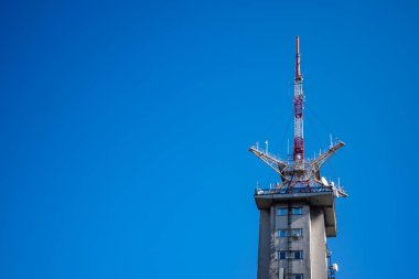 Mavi gökyüzüne karşı bir televizyon yayın kulesi. Ülke çapındaki televizyon yayın ağının bir parçası.