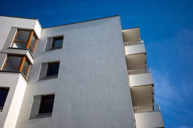 Mavi gökyüzüne karşı beyaz apartmanların cepheleri. Modern çoklu aile evleri.