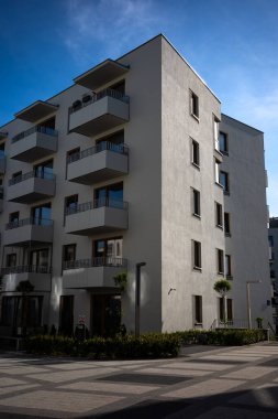Mavi gökyüzüne karşı beyaz apartmanların cepheleri. Modern çoklu aile evleri.