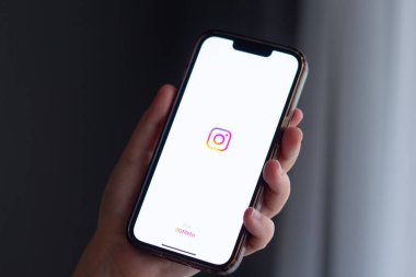 Kalininingrad, Rusya - 13 Eylül 2024. Kadın Iphone 'u evdeki ekranda Instagram uygulaması ile tutuyor. Facebook ve Meta logosu.