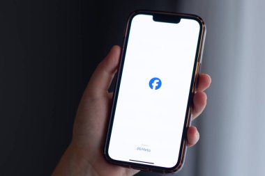 Kalininingrad, Rusya - 13 Eylül 2024. Kadın, evde Facebook uygulamalı Iphone 'u ekranda tutuyor. Facebook ve Meta logosu.