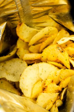 Patates cipsi dolu bir çanta. Çıtır cipsleri yakın. Pakette çıtır çıtır atıştırmalık. Sağlıksız fast food
