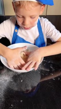 Küçük oğlu, annesinin ev mutfağında ev yapımı ekmek pişirmesine yardım ediyor. Ev yapımı ekmek. El yapımı hamur. Ev konseptinde yemek yapmak. Aile kavramı